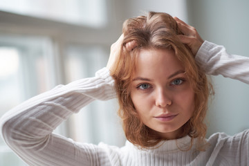 portrait of a beautiful curly girl. the mysterious face of a woman at the window.