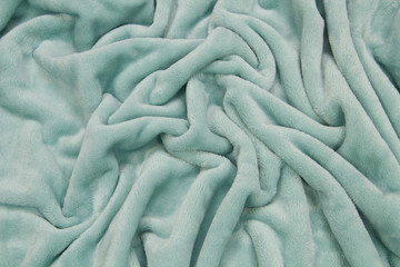 The blanket of furry fleece fabric. A background soft plush fleece material with a lot of relief folds