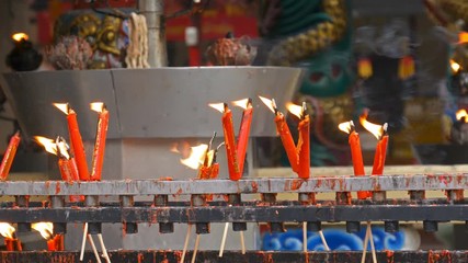 Video 4k of flame from burning red chinese candle in the temple
