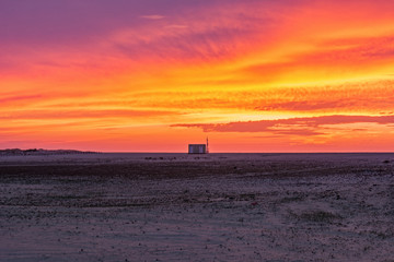 Fototapeta premium Beautiful sunset sky in Figuera da Foz in Portugal. Evening sky with empty beach and a beach hut in the distance.