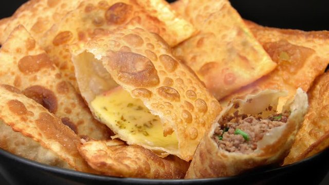Pan in traditional pastry called pastel stuffed with cheese and meat with one each open and smoke coming out