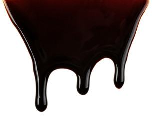 Melted chocolate dripping on white background. Dark chocolate.