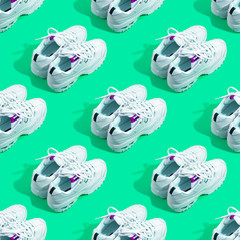 Pair of white sneakers on color background. Sport running concept. Many shoes seamless pattern