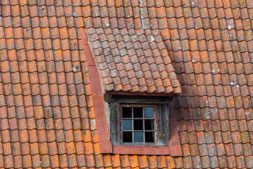 old pitched red tile roof with tiny garret casement widows.  Window on the roof.
