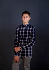 Portrait of a young man of Slavic appearance in a strict suit. Studio photography, plain gray tone