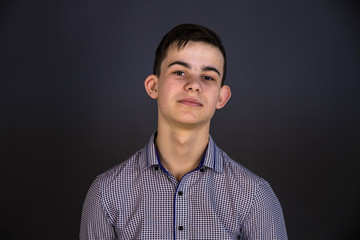 Obraz premium Portrait of a young man of Slavic appearance in a strict suit. Studio photography, plain gray tone