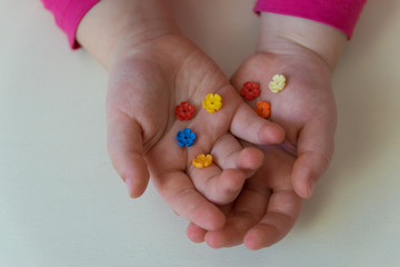 Child showing the little plastic toys in the hands.