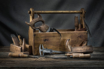 Still life - Old Wooden vintage toolbox with hammers, saw, chisels, plane and pliers in carpentry