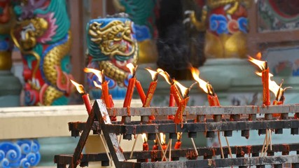 Video 4k of flame from burning red chinese candle in the temple