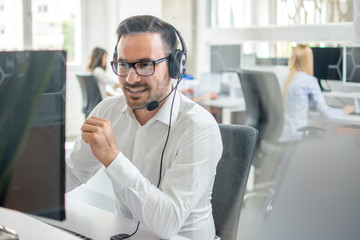 Confident customer support phone operator with headset working in call center