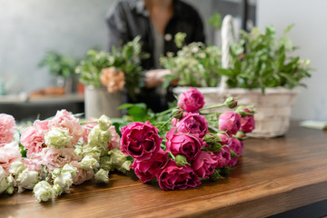 Woman florist create flower arrangement in a wicker basket. Beautiful bouquet of mixed flowers. Floral shop concept . Handsome fresh bouquet. Flowers delivery