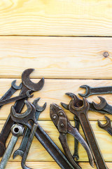 Rusty old tools are laid out on a wooden background