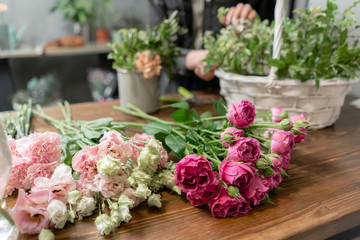Woman florist create flower arrangement in a wicker basket. Beautiful bouquet of mixed flowers. Floral shop concept . Handsome fresh bouquet. Flowers delivery