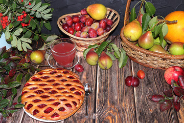 Cup of hot tea and dessert on an autumn wooden table with vegetables and fruits on a wooden table with leaves, flat lay, top view,. Cosiness and comfort in the house in the cold autumn,