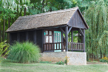 Old wooden log cabin on the meadow near forest
