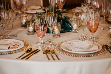 Table set for an event party or wedding reception. Beautiful glassware set on the table. Warm colours.
