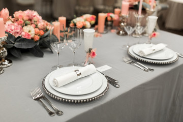 Part of stylish table setting with plate and cutlery. Nearby lies a white business card. Copy space