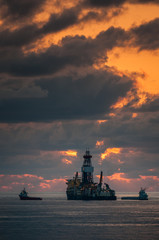 Long view of tanker in ocean at sunset