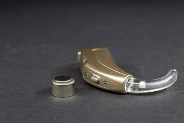 hearing aid on black background close-up with element