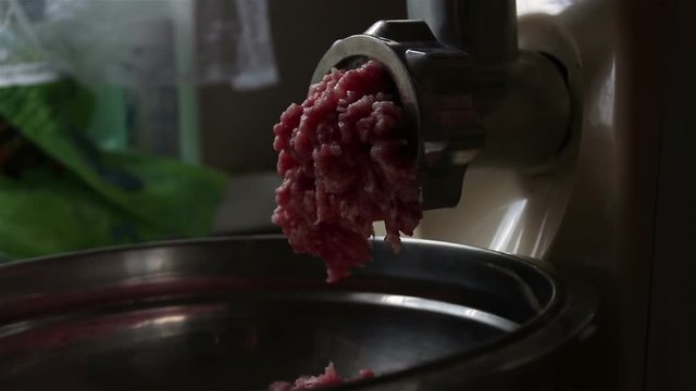 Close-up meat grinder grinds fresh meat into minced meat.Chef cooks fresh minced meat in an electric mincing machine.