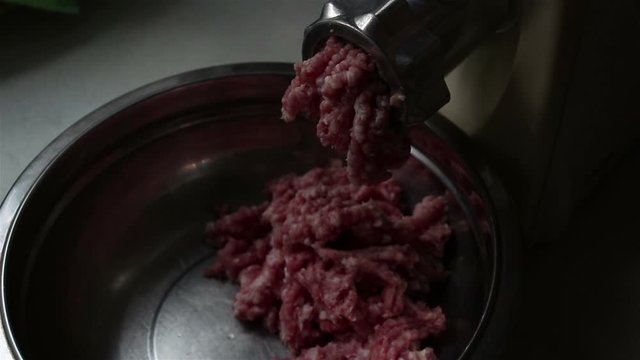 Close-up meat grinder grinds fresh meat into minced meat.Chef cooks fresh minced meat in an electric mincing machine.