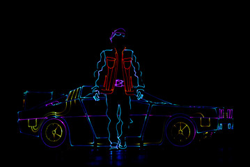 Laser show performance, dancers in suits with LED lamp near car