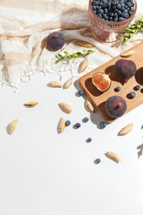 Fototapeta na wymiar Figs, pear and blueberries on a cutting wooden board.
