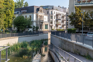 View of uncovered river Elstermuehlgraben in Leipzig with a heron in the foreground