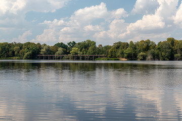 Fototapeta premium View of the popular lake Auensee in the north of Leipzig with old bridge and miniature railway