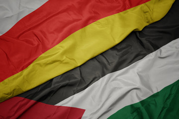 waving colorful flag of palestine and national flag of south ossetia.