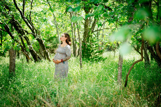 Side view of pregnant woman in forest