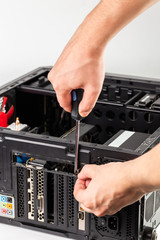 hands unscrewing a video card bracket while maintenance personal computer hardware with selective...