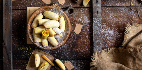 homemade shortbread yellow baked rolled cookies or bagels with apple jam in wooden round plate