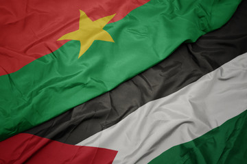 waving colorful flag of palestine and national flag of burkina faso.