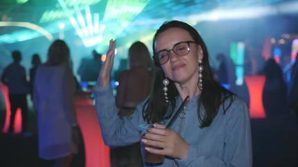 happy women drinks during dancing at night party in lumiere lights at disco club, nightlife,