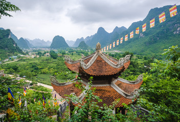 Vue aérienne sur une vallée et montagnes karstiques avec un temple au premier plan, province de Cao Bang, Vietnam.