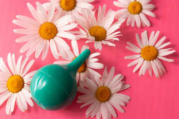 green douche enema bowel washing, rinse mouth, nose top view on a pink background