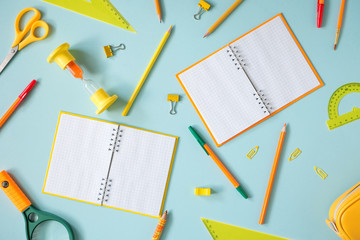 Colored different school supplies on soft blue paper background. Back to school background. Flat lay, top view, copy space