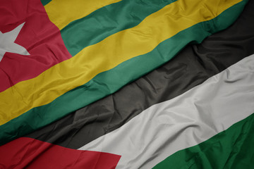 waving colorful flag of palestine and national flag of togo.
