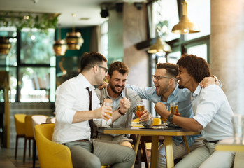 Friends are happy while watching game at te ub and drinking beer.