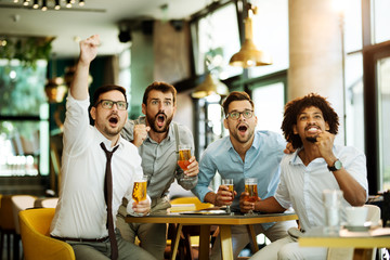 Friends are happy while watching game at te ub and drinking beer.