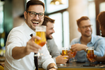portrait of a young guy holding a glass of beer in his hand