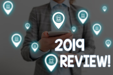 Handwriting text writing 2019 Review. Conceptual photo remembering past year events main actions or good shows Woman wear formal work suit presenting presentation using smart device