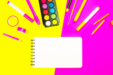 School supplies on yellow and pink background with copy space. Back to school concept.