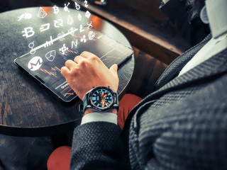 hipster adult rich businessman using his pro tablet in cafe pub outdoors and connect remotely to blockchain coin exchange for-ex stockg market interface coin symbols