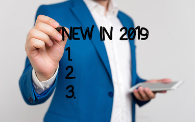 Conceptual hand writing showing New In 2019. Concept meaning what will be expecting or new creation for the year 2019 Businessman blue suite and white shirt pointing with finger