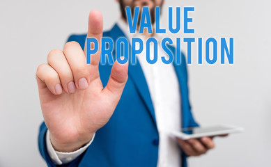 Conceptual hand writing showing Value Proposition. Concept meaning feature intended to make a company or product attractive Businessman with pointing finger in front of him
