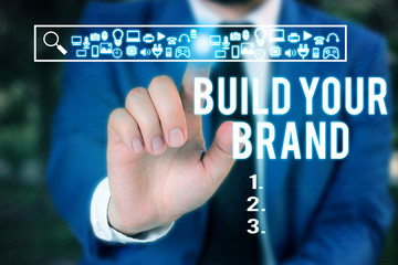 Word writing text Build Your Brand. Business photo showcasing enhancing brand equity using advertising campaigns Male human wear formal work suit presenting presentation using smart device