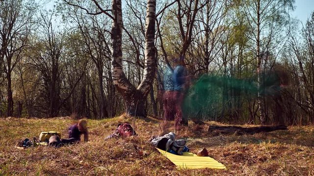Long exposure timelapse of a family packing tent while trekking in early spring with blurried people