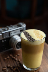 Traditional russian raff coffee with spices on a vintage background with wooden table and retro camera